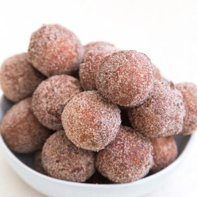 apple cider doughnut holes stacked in a white bowl