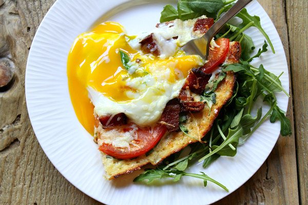 Cauliflower Crust Bacon and Egg Pizza slice with broken egg