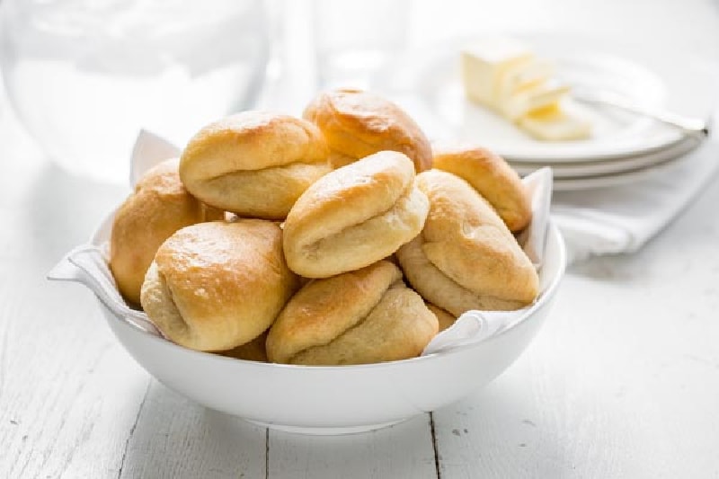 parker house rolls in a white bowl