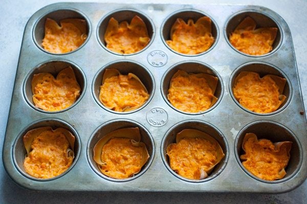 Easy Buffalo Chicken Wonton Cups baking in a cupcake pan