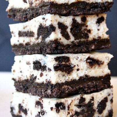 four pieces of cookies and cream cheesecake bars stacked on top of each other