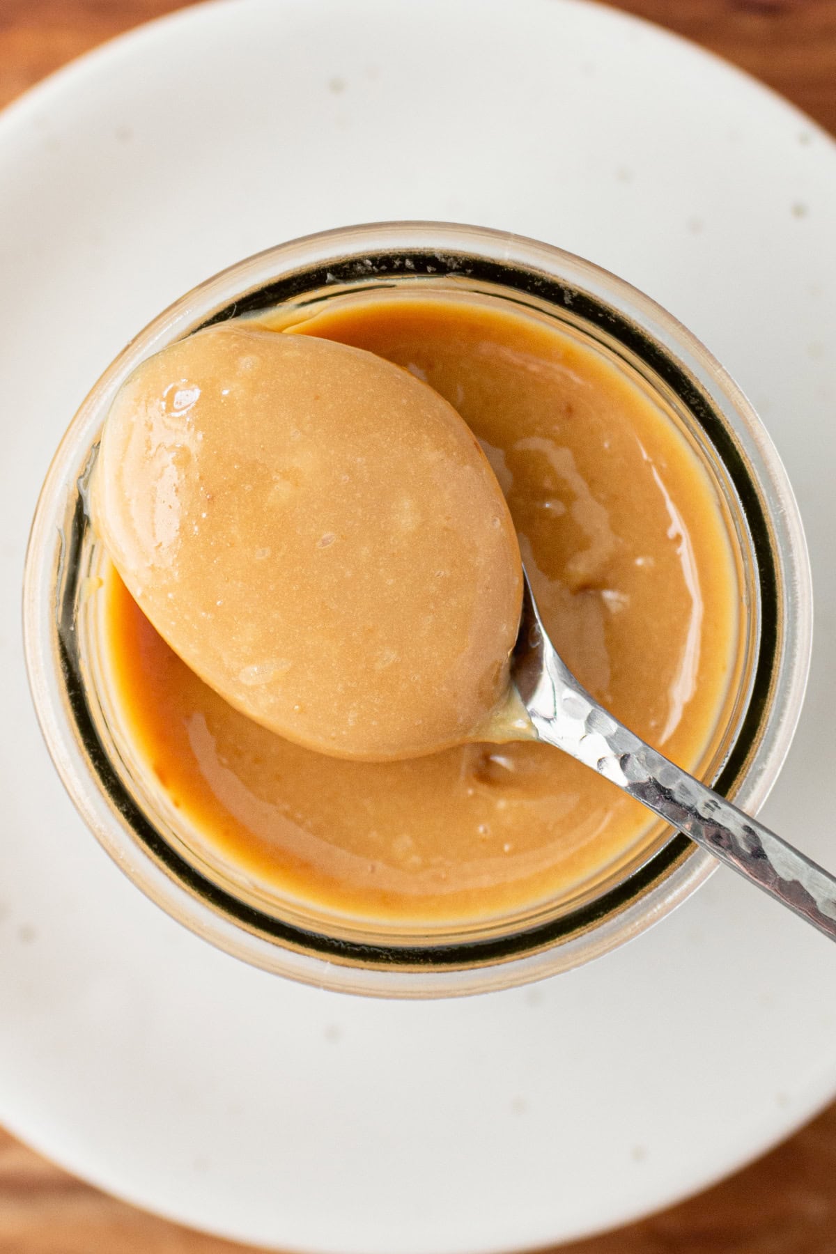 Homemade Dulce de Leche recipe made in the oven: by RecipeGirl.com spoon in homemade dulce de leche