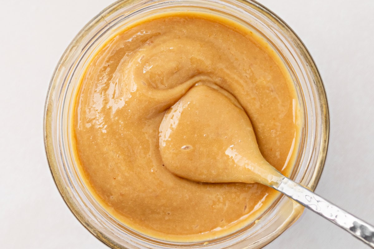Homemade Dulce de Leche recipe made in the oven: by RecipeGirl.com spoonful of homemade dulce de leche over jar