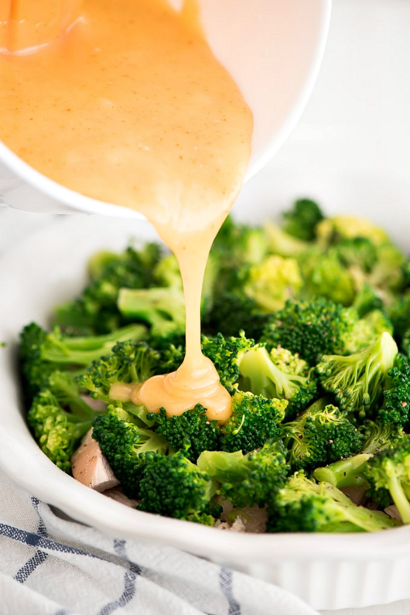 Chicken Divan recipe from RecipeGirl.com #chicken #divan #easy #familyfriendly #dinner #recipe #RecipeGirl Sauce on broccoli for Chicken Divan