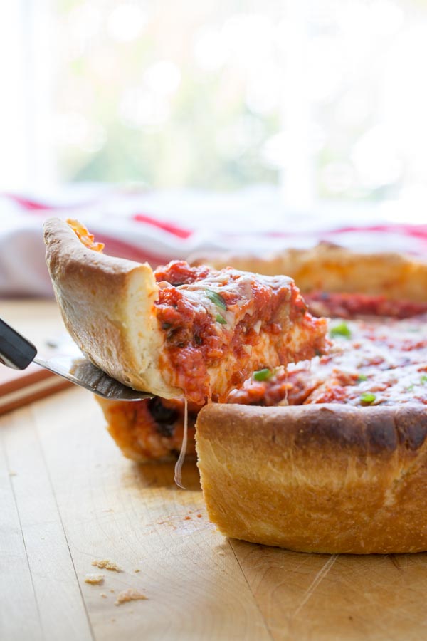 chicago style deep dish pizza pulling out a slice with a spatula