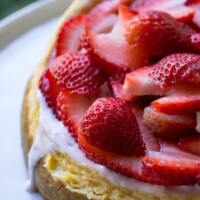 Instant Pot Cheesecake on a white plate with strawberries on top