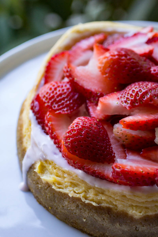 Instant Pot Cheesecake on a white plate with strawberries on top