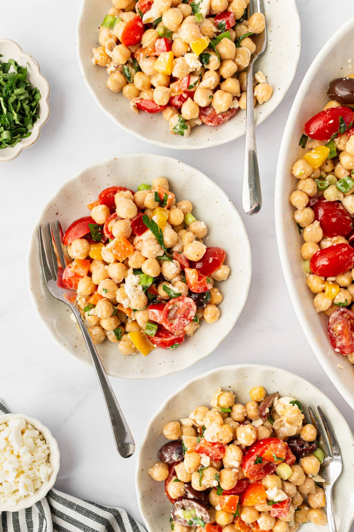 This Mediterranean Chickpea Salad is a super popular, delicious and easy salad recipe from RecipeGirl.com. three servings of mediterranean chickpea salad in bowls