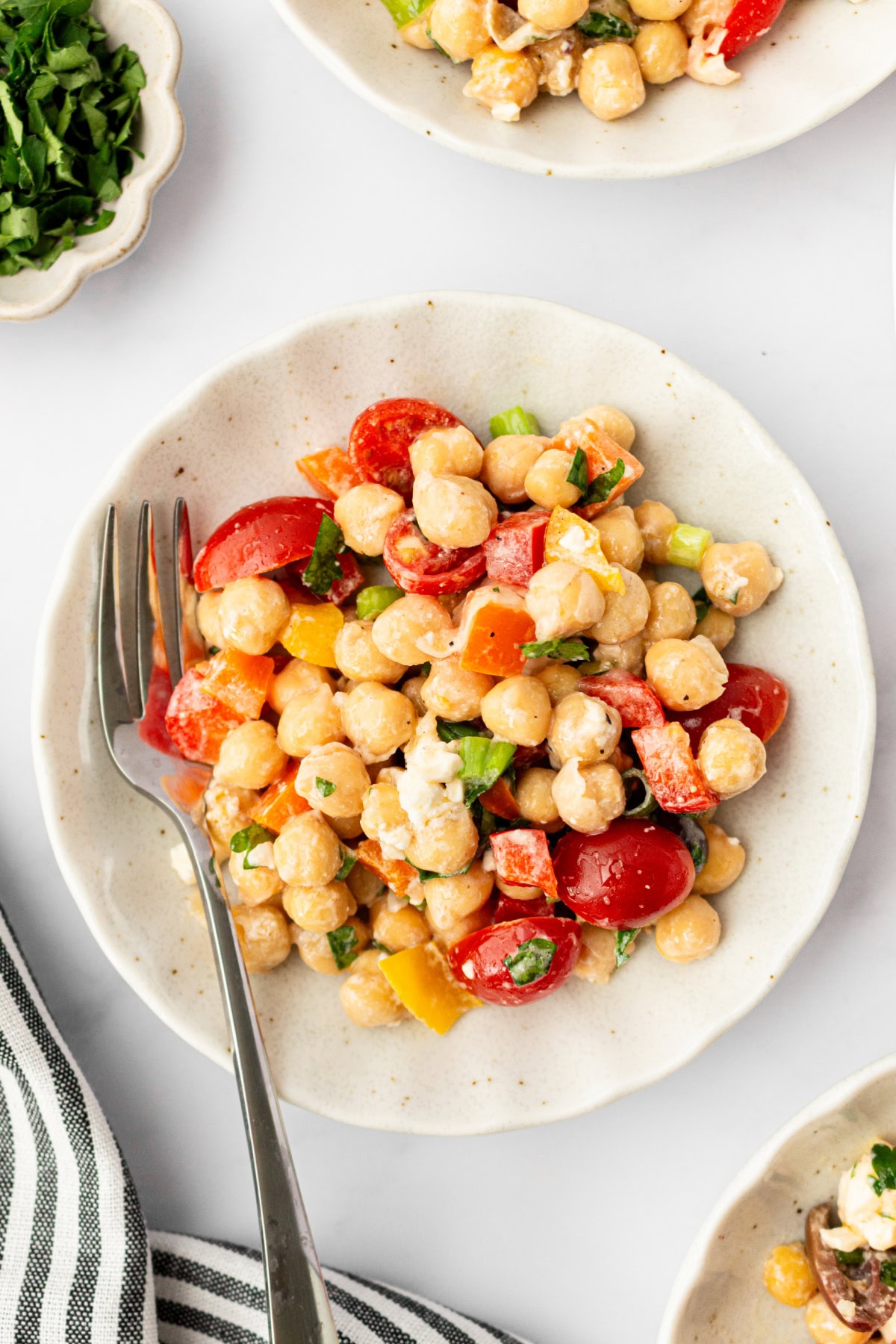 This Mediterranean Chickpea Salad is a super popular, delicious and easy salad recipe from RecipeGirl.com. serving of mediterranean chickpea salad on plate with fork