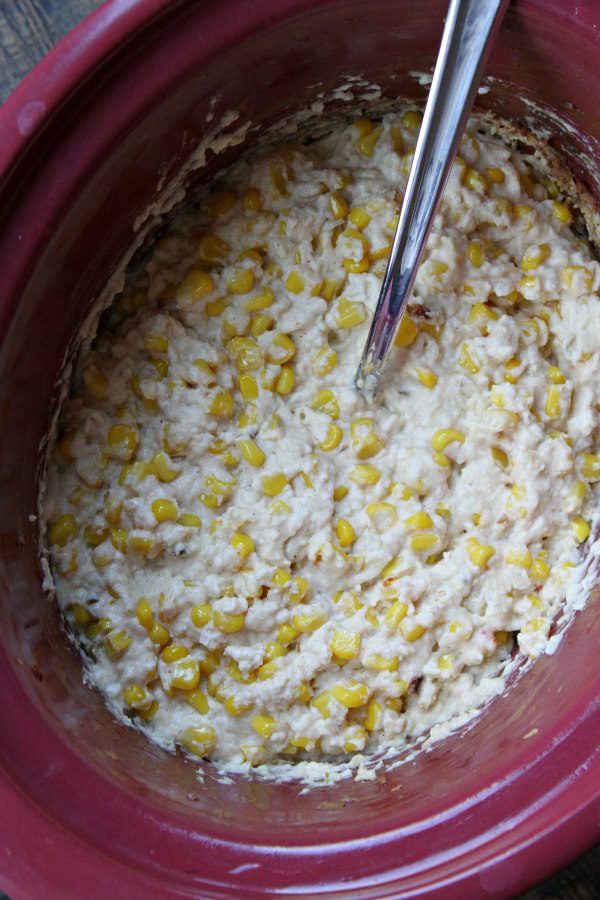Mexican Street Corn Dip cooking in the Slow Cooker with a serving spoon