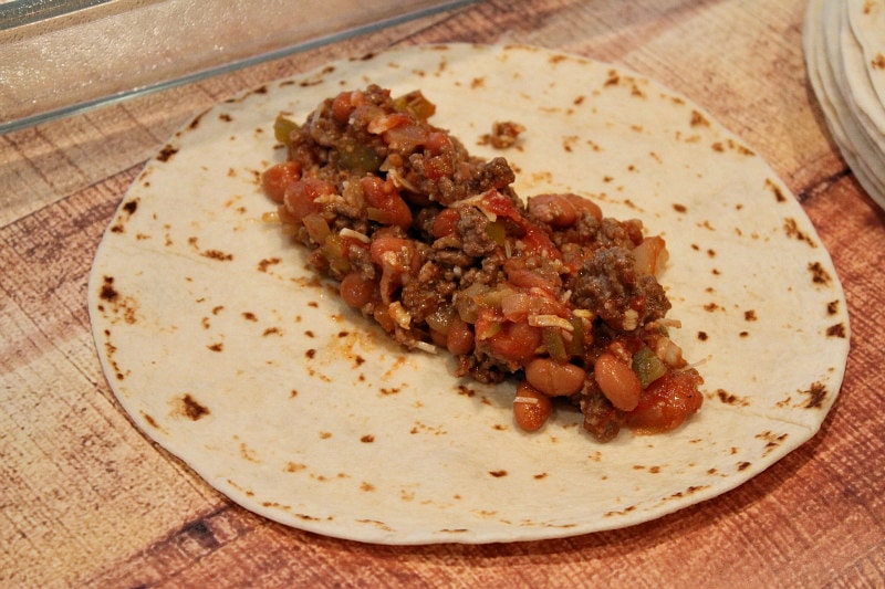 Easy Beef Burrito Casserole recipe by RecipeGirl.com #beef #burrito #casserole #recipe #RecipeGirl a tortilla with beef and bean filling on top of it