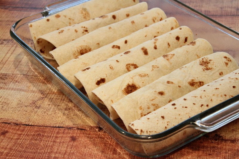 Easy Beef Burrito Casserole recipe by RecipeGirl.com #beef #burrito #casserole #recipe #RecipeGirl beef burrito casserole assembled and ready for the oven in a glass casserole dish