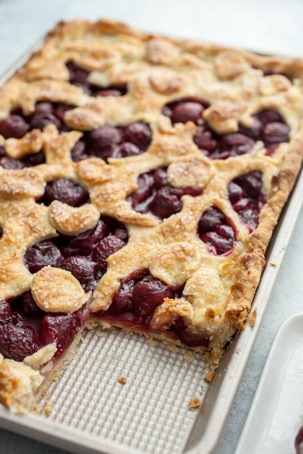 fresh cherry slab pie with a slice cut out of it