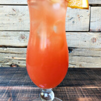 hurricane cocktail in a hurricane glass with a wooden background