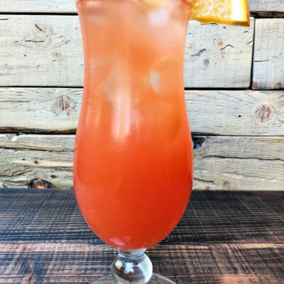 hurricane cocktail in a hurricane glass with a wooden background