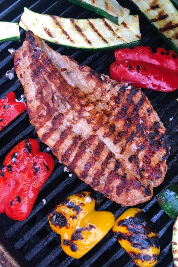 grilling pork tenderloin and vegetables on the grill