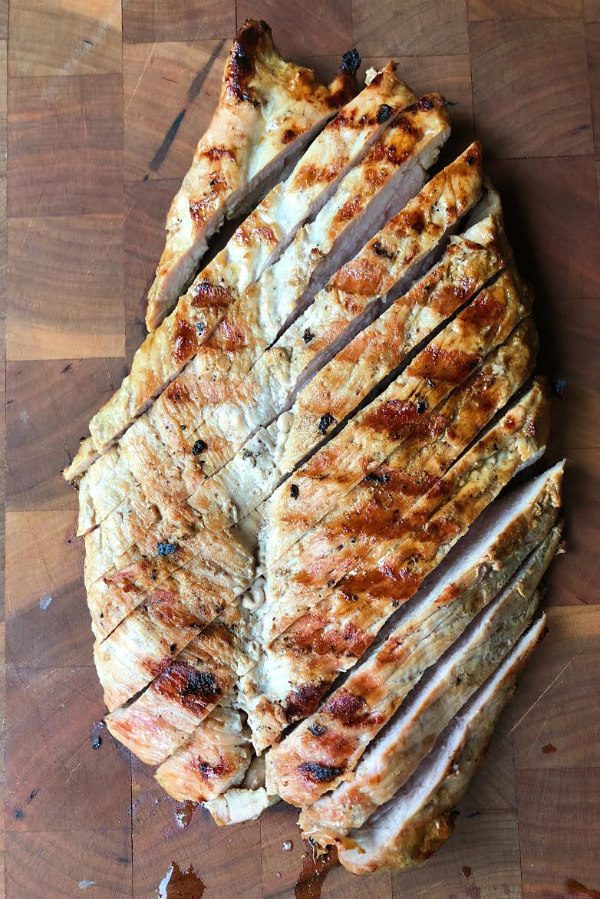 Grilled Pork Tenderloin sliced on a wooden cutting board