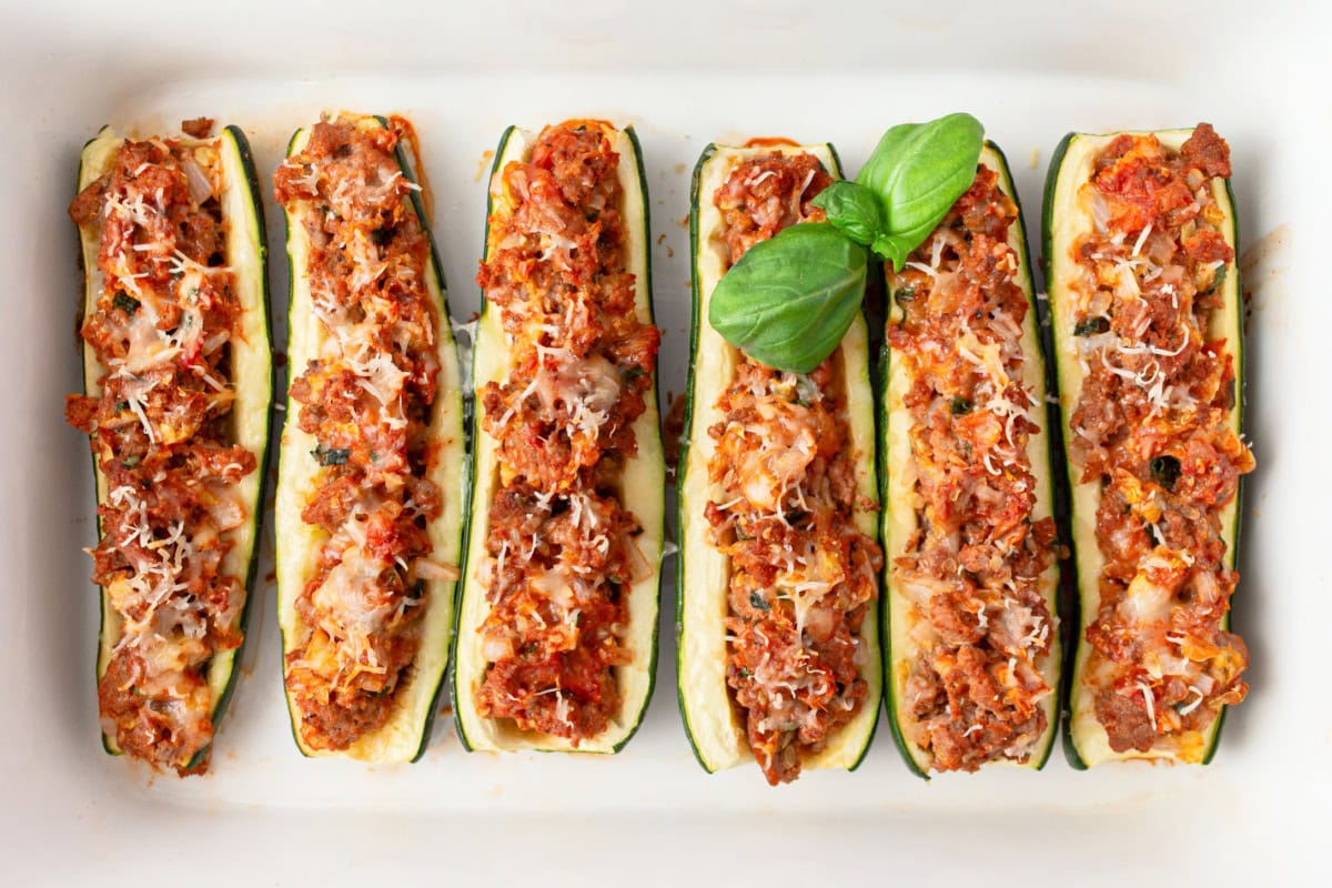 several sausage stuffed zucchini in a baking pan