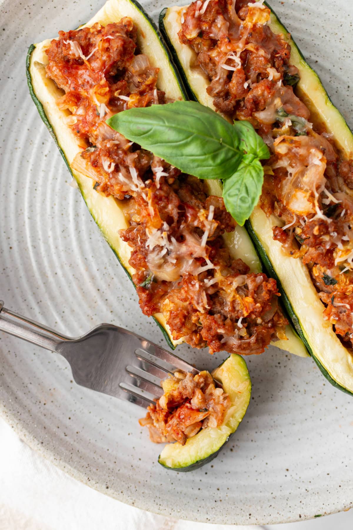Sausage Stuffed Zucchini Boats Recipe : from RecipeGirl.com : summer zucchini recipe fork cutting part of sausage stuffed zucchini on plate