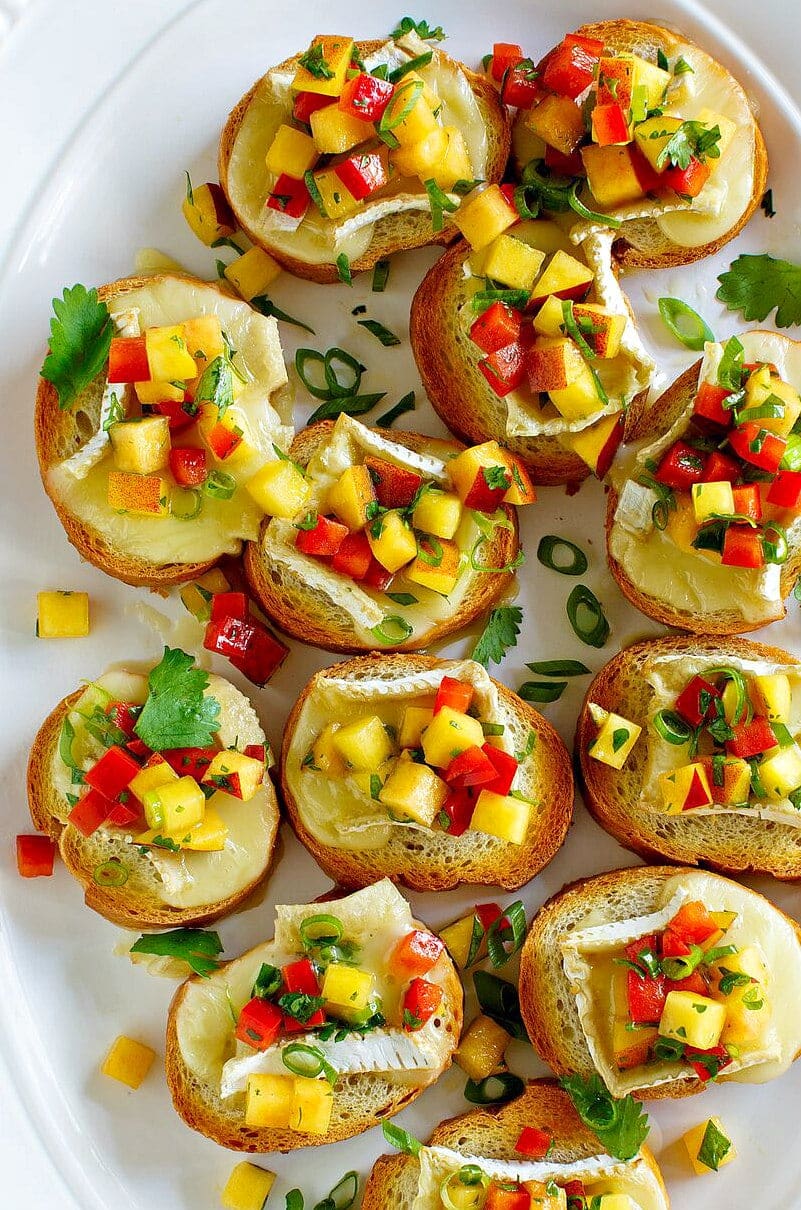 overhead shot of peach and brie bruschetta on a white serving platter