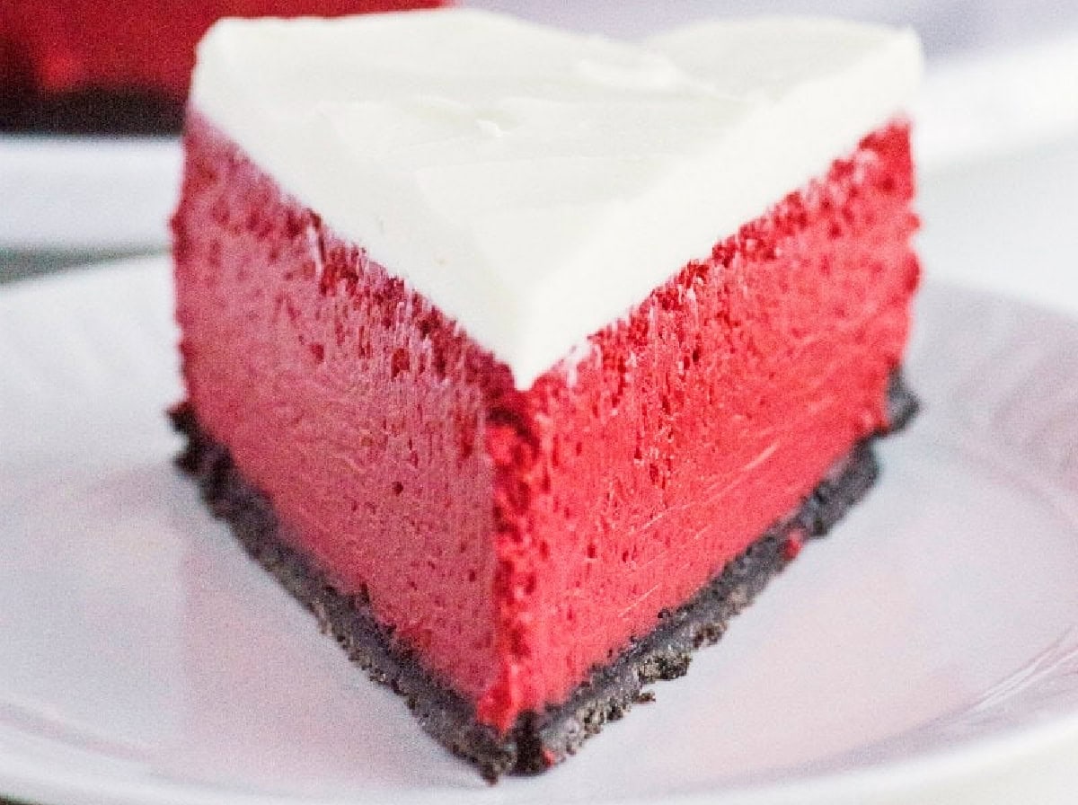 This gorgeous Red Velvet Cheesecake has a creamy red velvet filling, chocolate Oreo crust and rich cream cheese frosting. It's an impressive make-ahead dessert for Christmas, Valentine's Day, holidays and special occasions. close up slice red velvet cheesecake