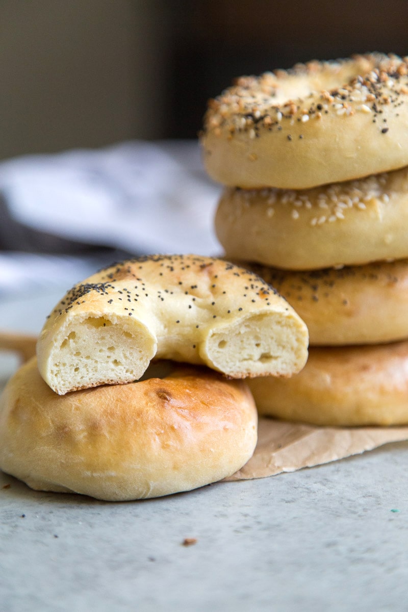 one half of a bagel with stack of 2 Ingredient Bagels in background