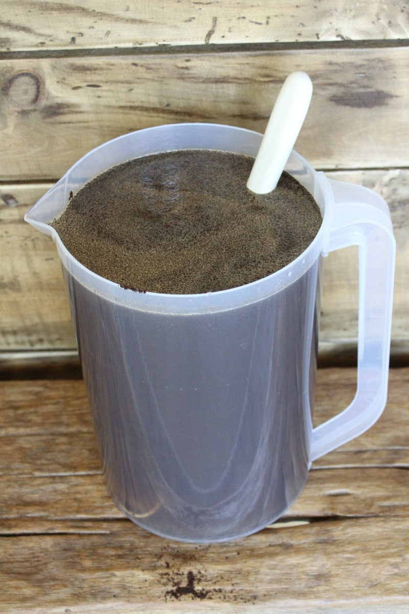 pitcher of cold brew coffee with coffee grounds marinating in the pitcher