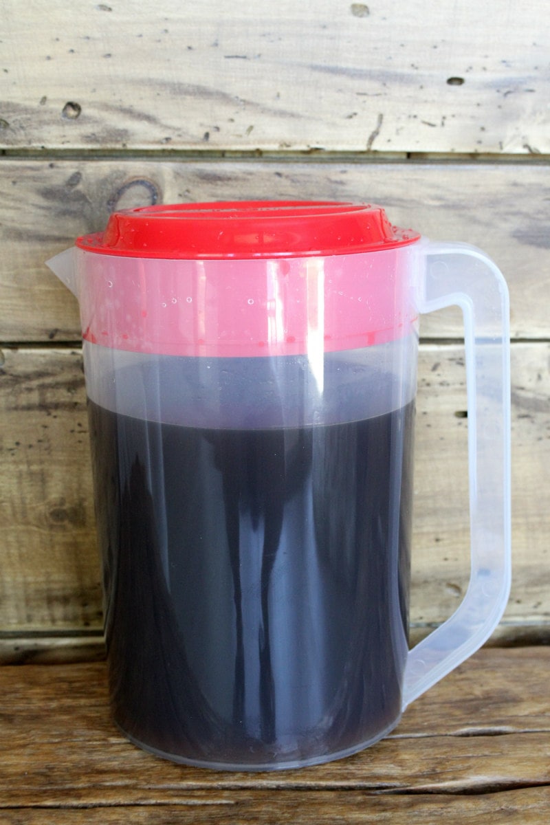 pitcher of cold brew coffee displayed with a wooden background