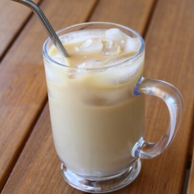 Cold Brew Coffee in a glass mug with a straw sitting on a wooden table