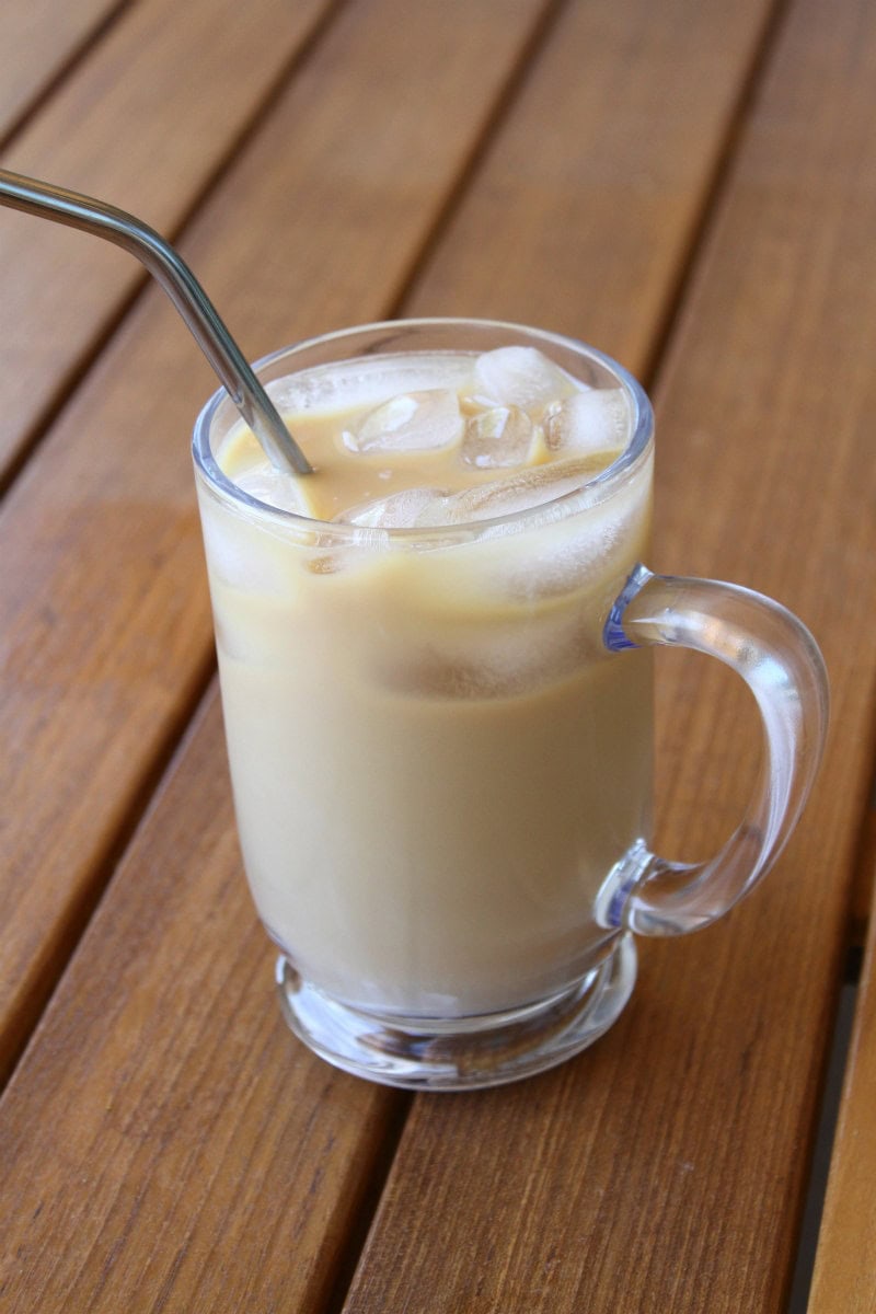 Cold Brew Coffee in a glass mug with a straw sitting on a wooden table