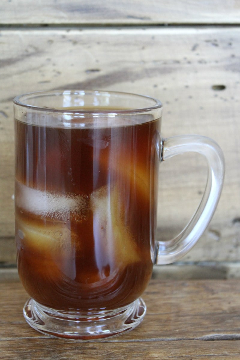 glass mug of cold brew coffee with a wooden backdrop