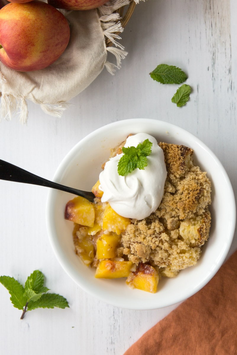 Serving of Peach Cobbler French Toast Casserole with whipped cream on top