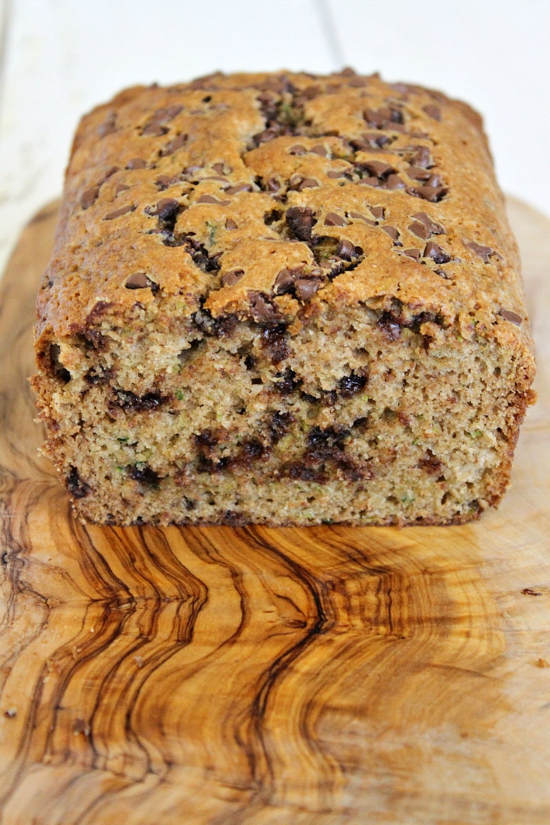 loaf of chocolate chip zucchini bread cut open on wooden cutting board