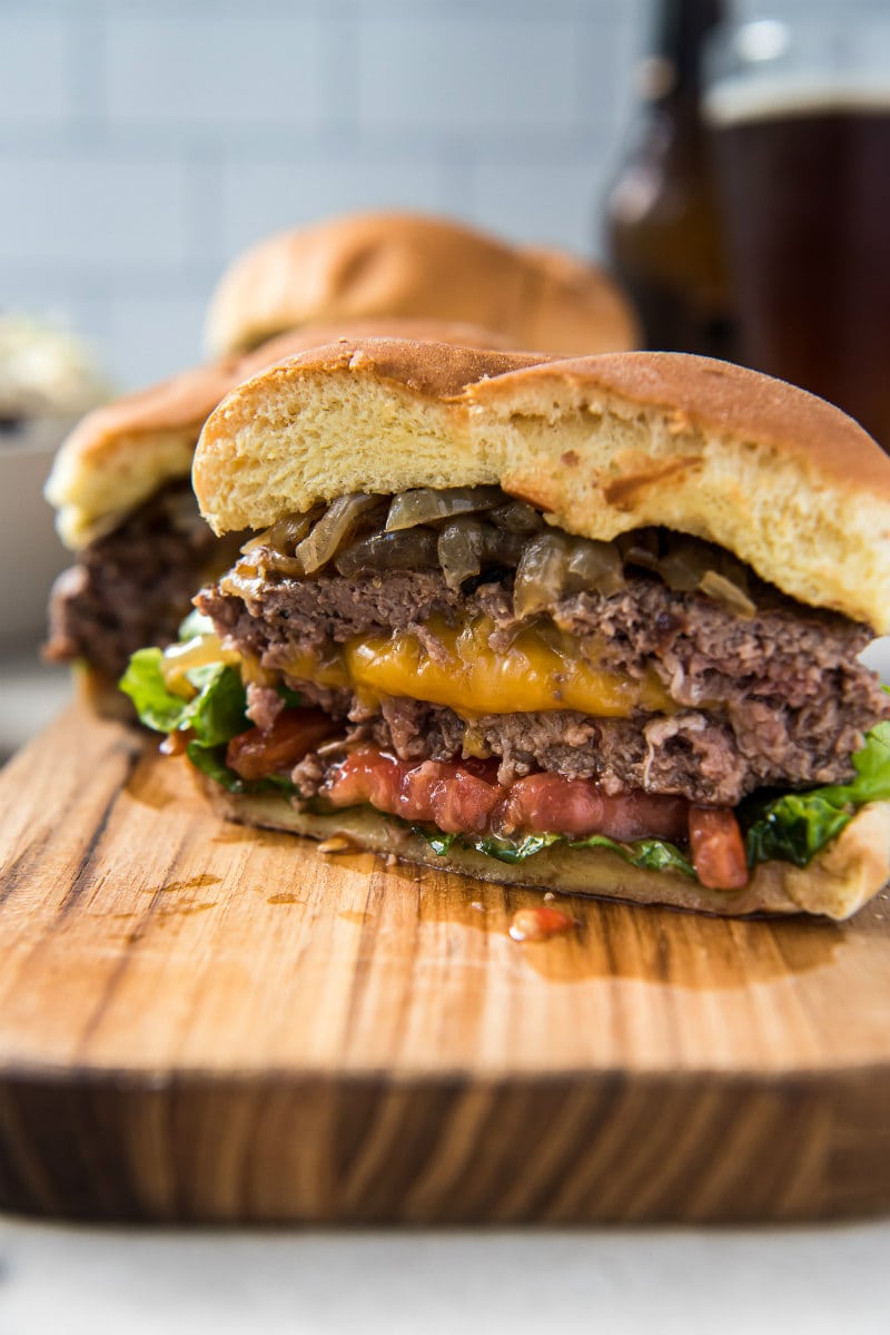 Jucy Lucy Burgers recipe from RecipeGirl.com #jucy #juicy #lucy #burger #burgers #minneapolis #copycat #recipe #RecipeGirl jucy lucy burger cut in half to see the cheese and tomato on the inside