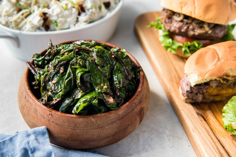 bowl of greens served alongside burgers