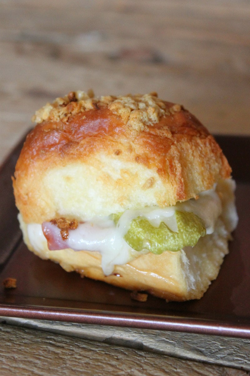 Baked Cuban Slider sitting on a copper metal tray