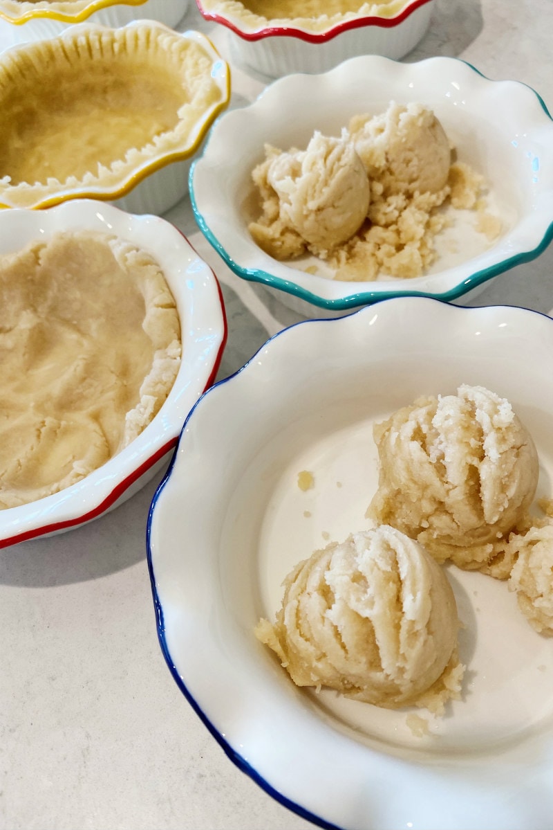 pressing dough into mini pie pans