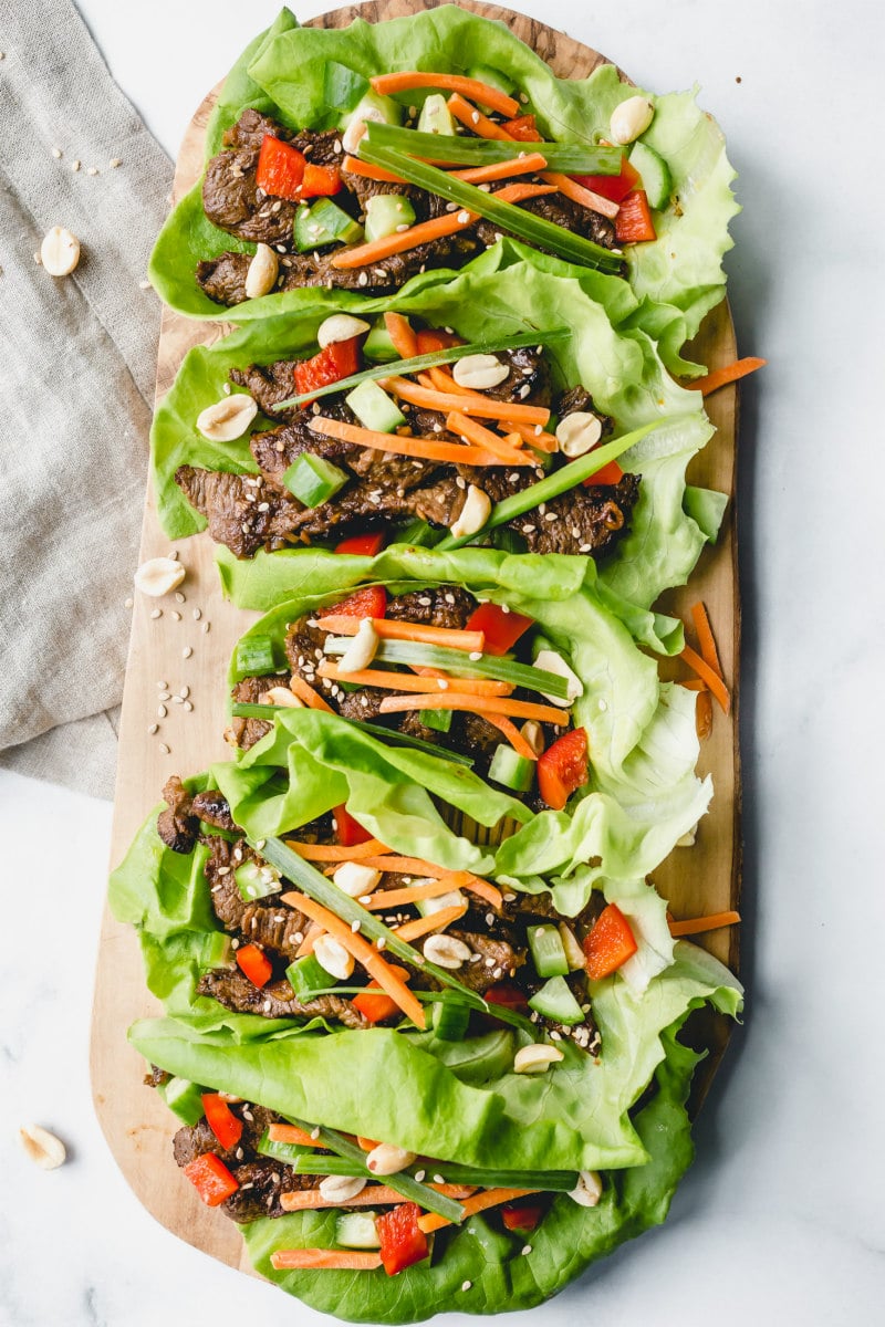 Bulgogi Beef Lettuce Wraps recipe from RecipeGirl.com #Bulgogi #korean #beef #lettuce #wraps #recipe #RecipeGirl bulgogi beef lettuce wraps laid out on a wooden cutting board