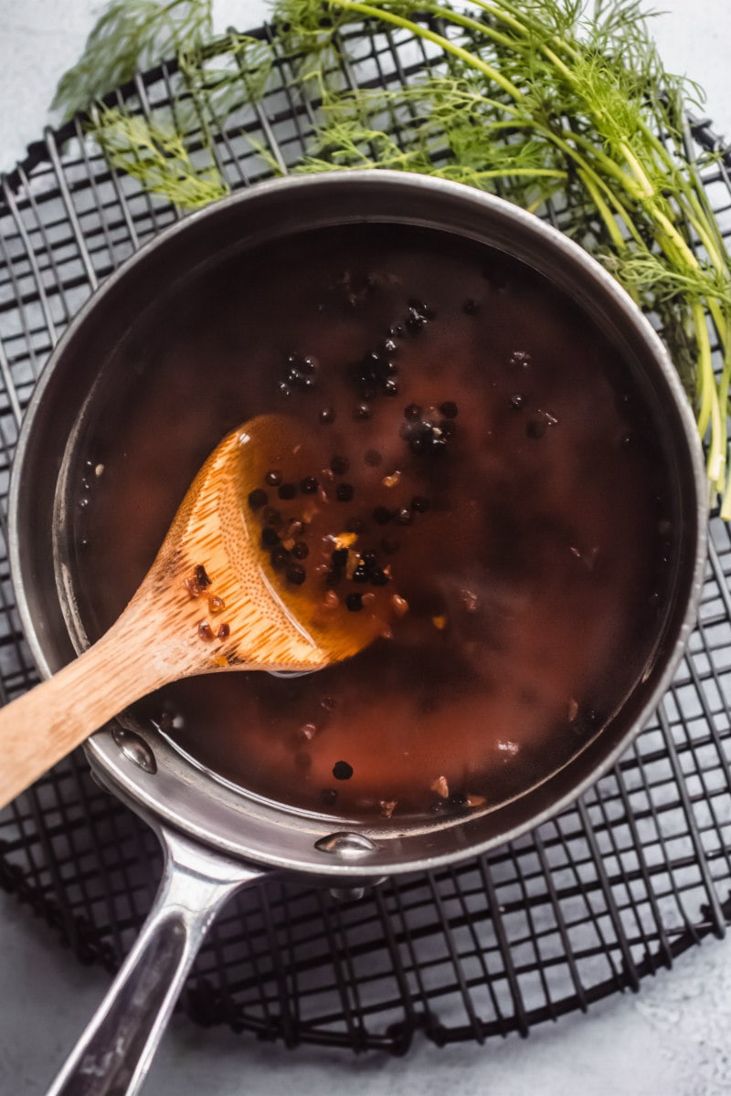 overhead shot of wooden spoon stirring spices in a saucepan