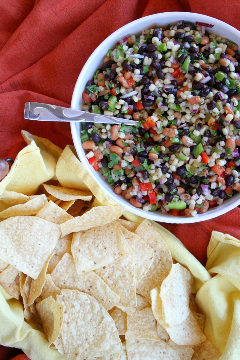 overhead shot of texas caviar dip in a white bowl served with tortilla chips