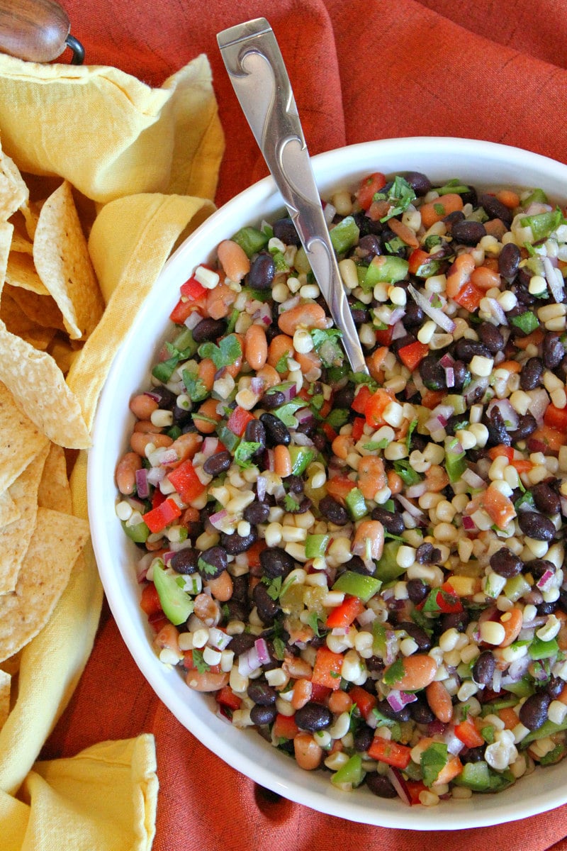 overhead shot of texas caviar in a white bowl served with tortilla chips
