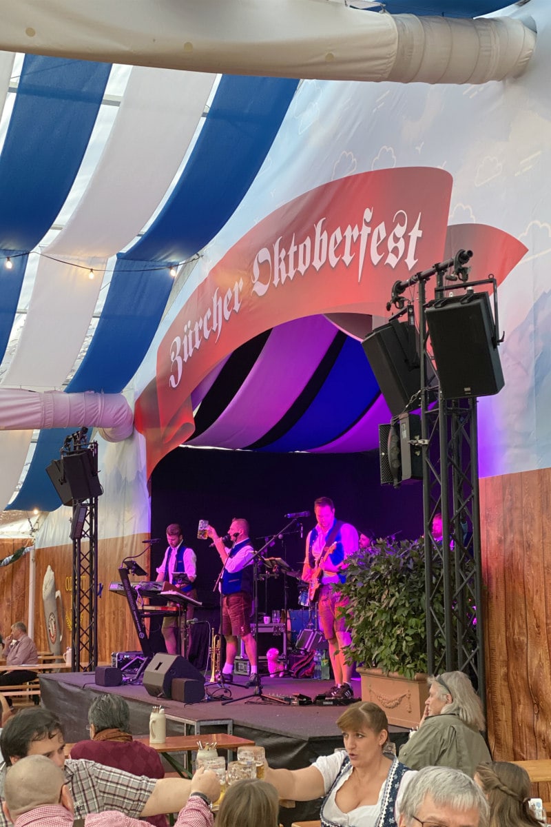 Oktoberfest in Zurich, Switzerland- musicians on stage and people toasting with beer