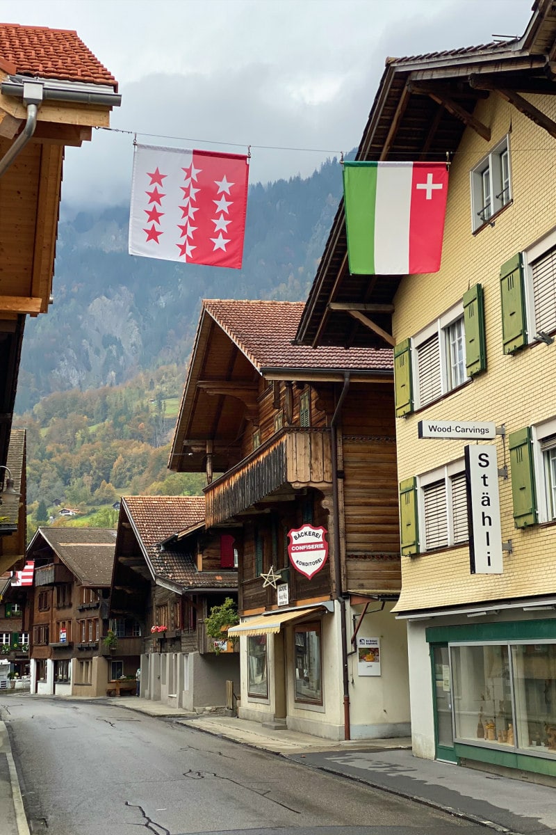 Looking down the main street of the Village of Brienz, Switzerland. Storefronts and flags hanging