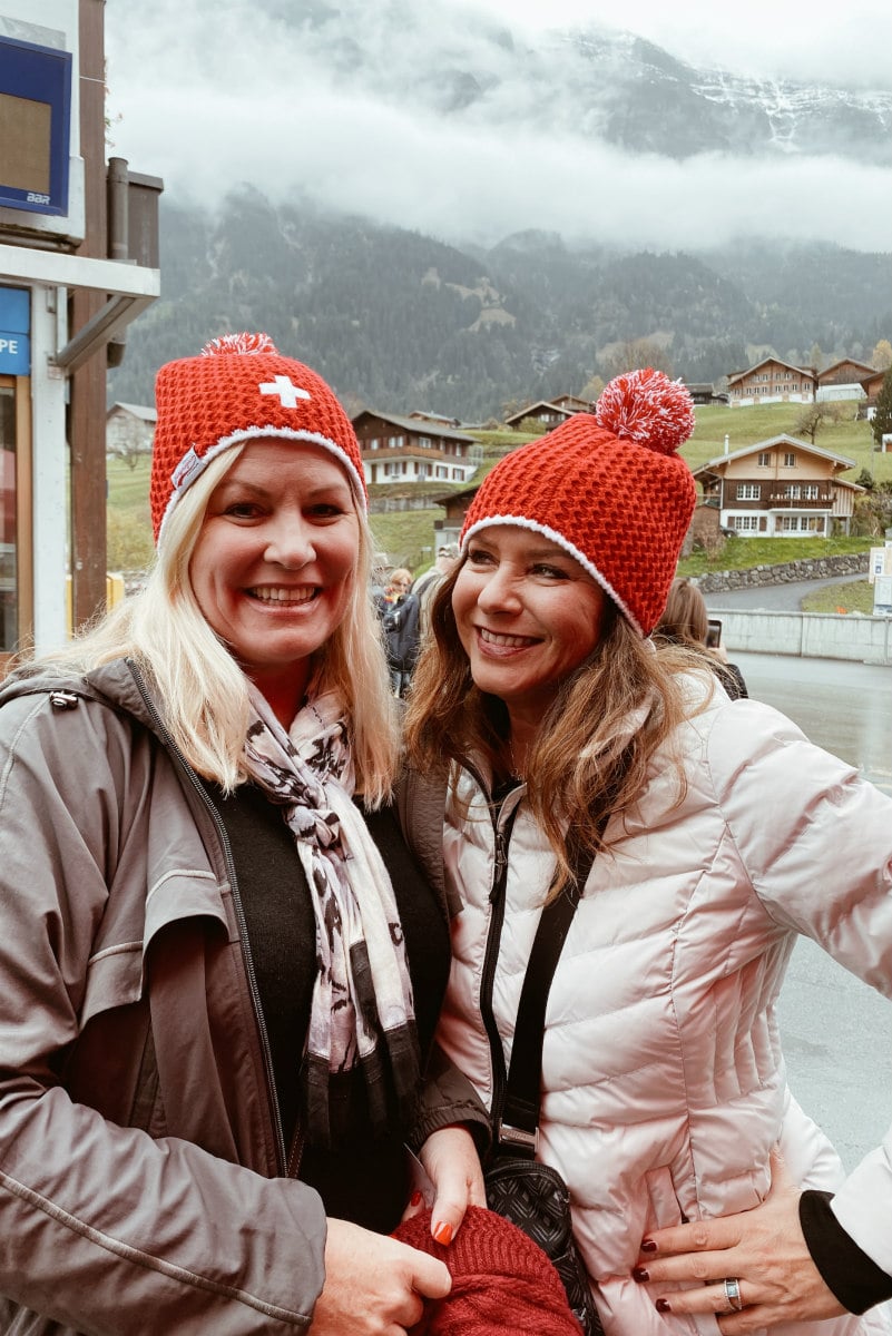 Two girls with red ski hats posing for a photo Below the Swiss Alps