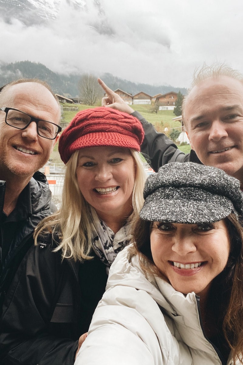 Two couples Standing under the clouded Swiss Alps for a photo