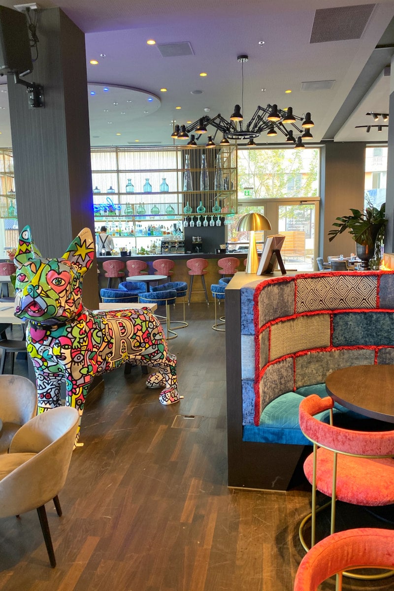 lobby of the Renaissance Zurich Tower Hotel with colorful art dog piece and lobby bar and tables