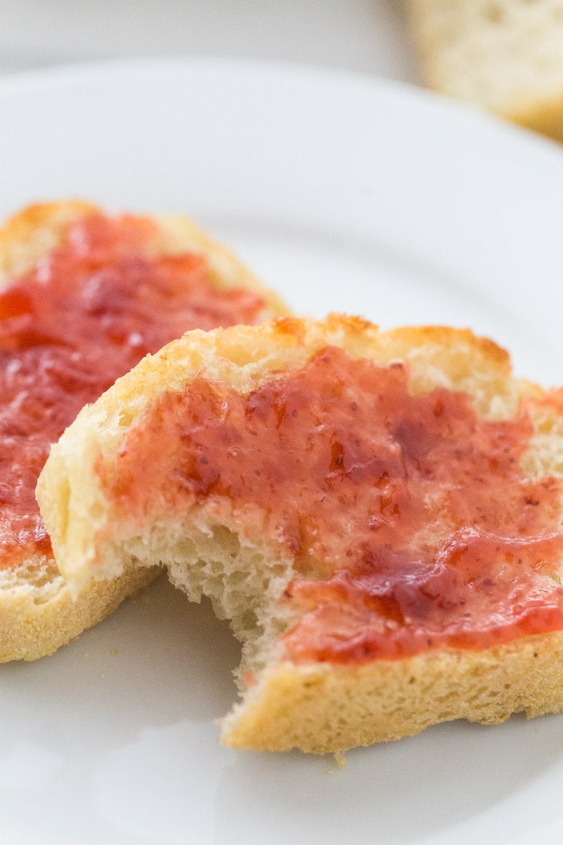 Slices of Toasted English Muffin Bread with Jam - one with a bite out of it