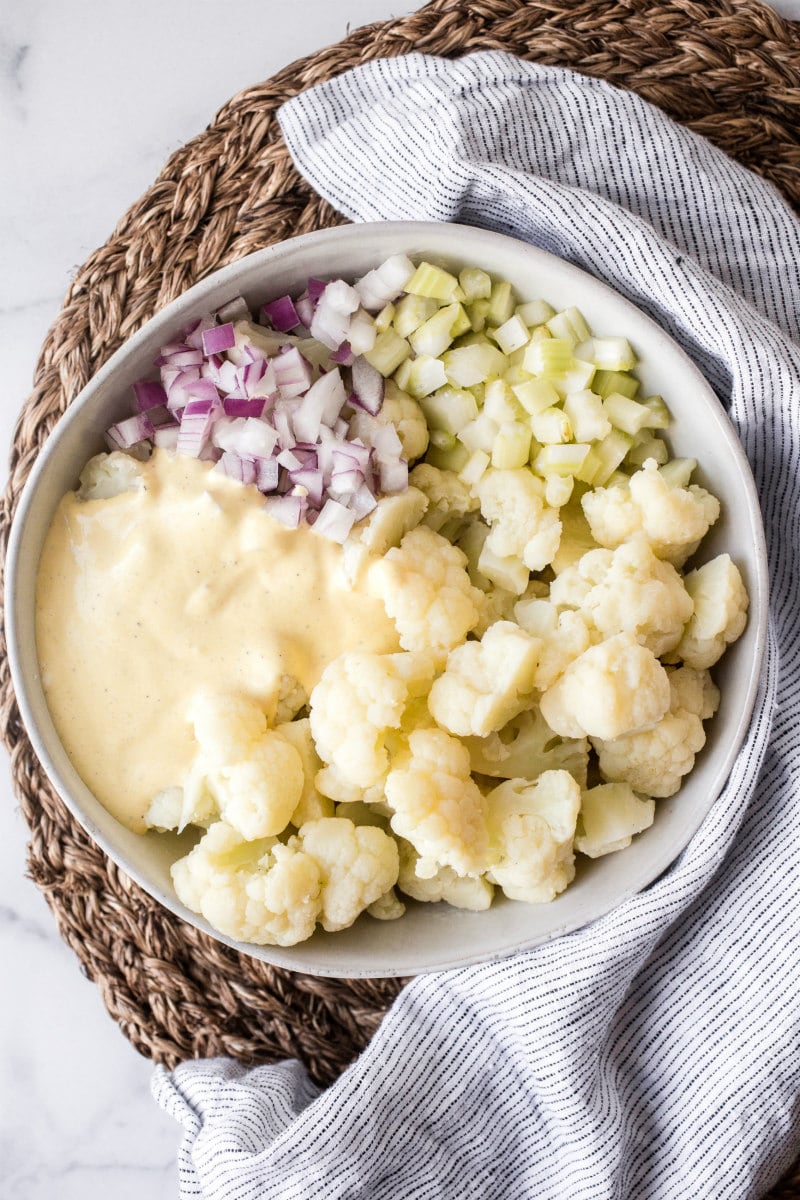 ingredients for cauliflower potato salad in a white bowl