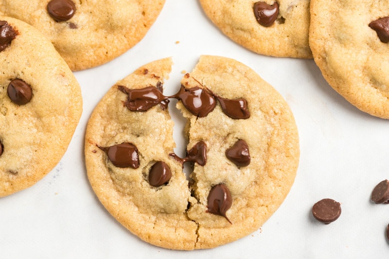 overhead shot of a chocolate chip cookie pulled apart to show gooey melted chocolate chips