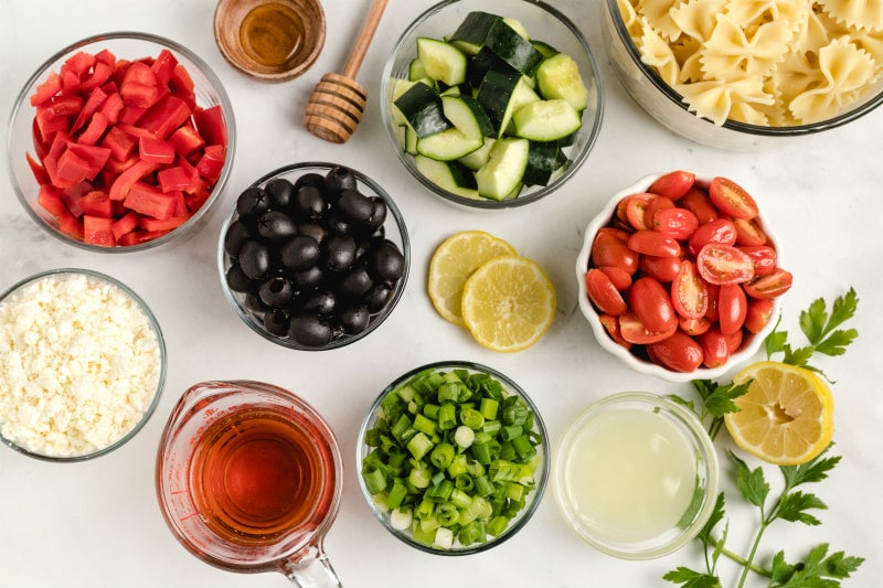 overhead shot of ingredients for bow tie pasta salad in display bowls